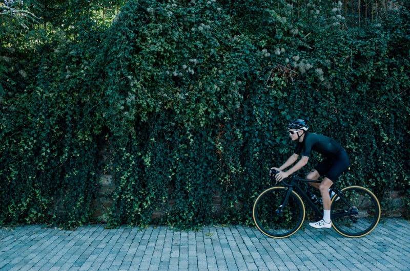 Man Riding His Bike With A Grass Wall Background